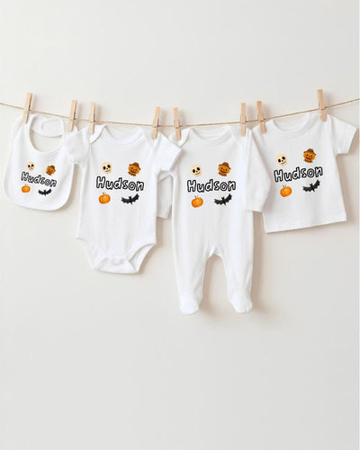 A collection of white baby clothes, including bodysuits and bibs, hanging on a clothesline.