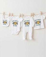 A collection of baby clothes, including onesies and bibs, hanging on a clothesline.