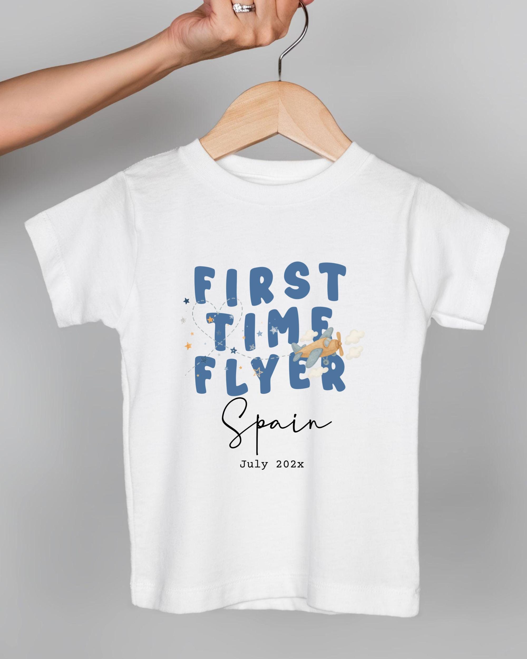A white t-shirt with the text "FIRST TIME FLYER Spain July 2023" printed on it.