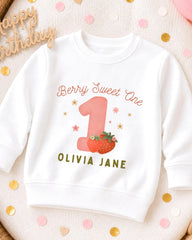 A white sweatshirt with a personalized design for a first birthday celebration.