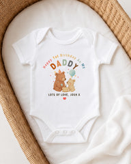 A white onesie with a personalized message and illustrations of two bears, one larger and one smaller, is displayed on a white blanket.