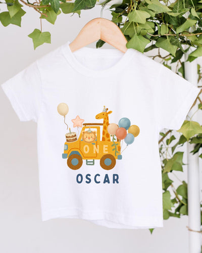 A white t-shirt with a graphic design featuring a yellow car, a giraffe, and balloons, along with the text "ONE OSCAR".