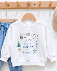 A white sweatshirt with a personalized Christmas-themed design hanging on a wooden hanger.