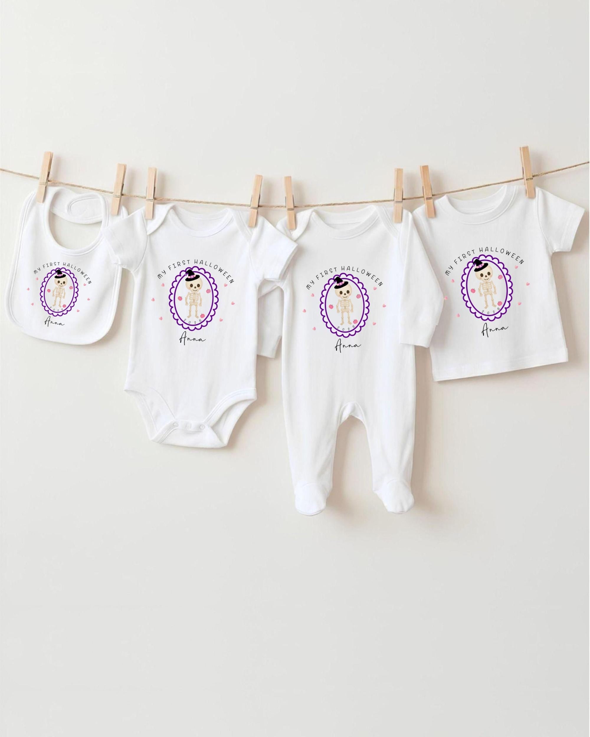 A row of white baby clothes, including onesies and bibs, hanging on a clothesline.