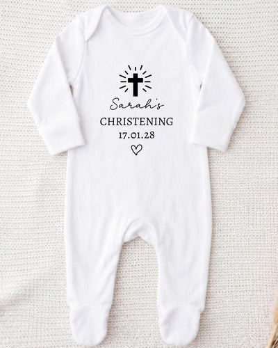A white onesie with a black cross and text printed on it.