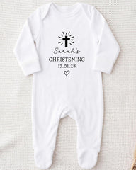 A white onesie with a black cross and text printed on it.