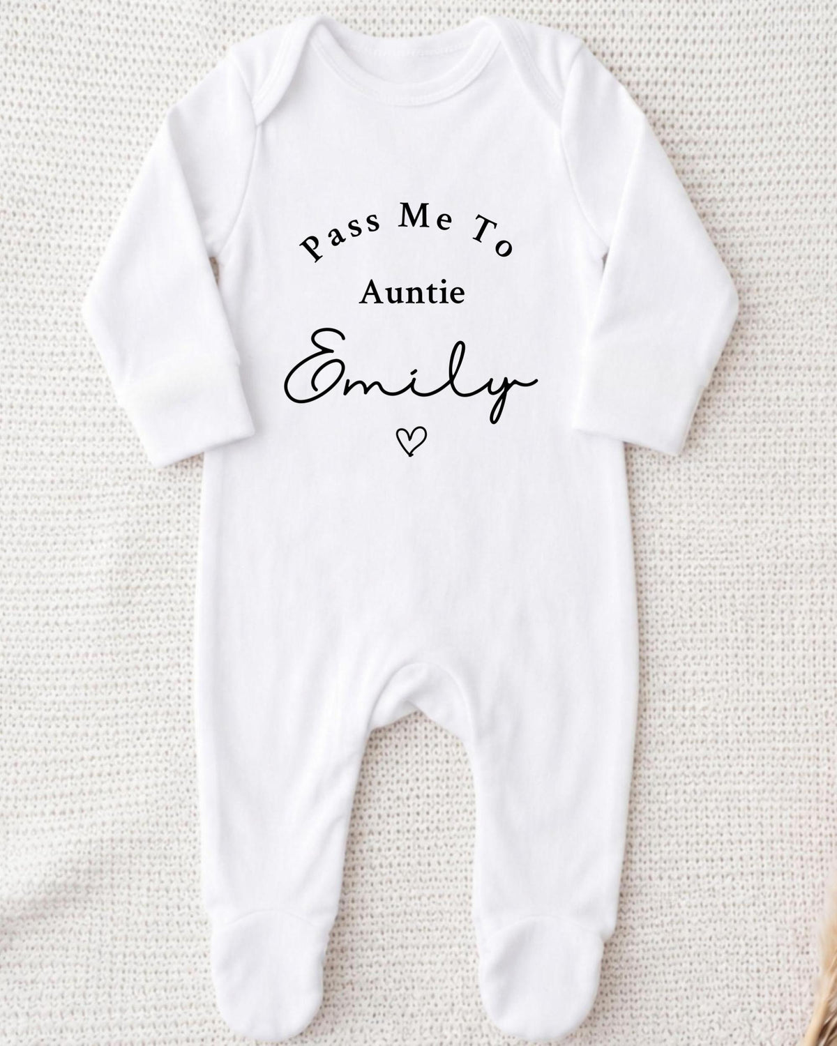 A white onesie with the text "Pass Me To Auntie Emily" printed on it.
