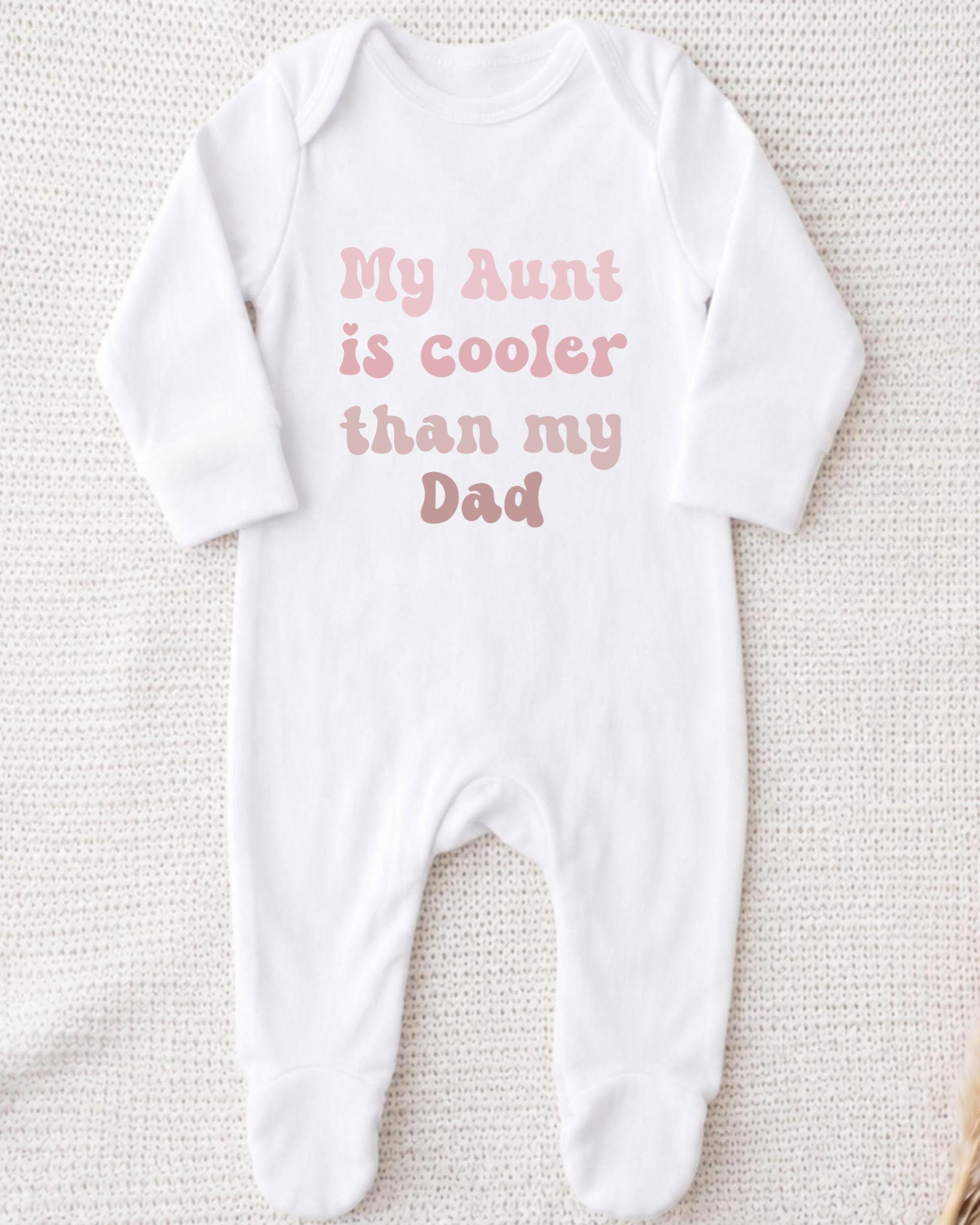 A white onesie with the text "My Aunt is cooler than my Dad" printed on it.