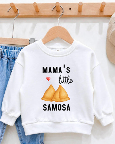 A white sweatshirt with a graphic design and text printed on it, hanging on a wooden hanger.