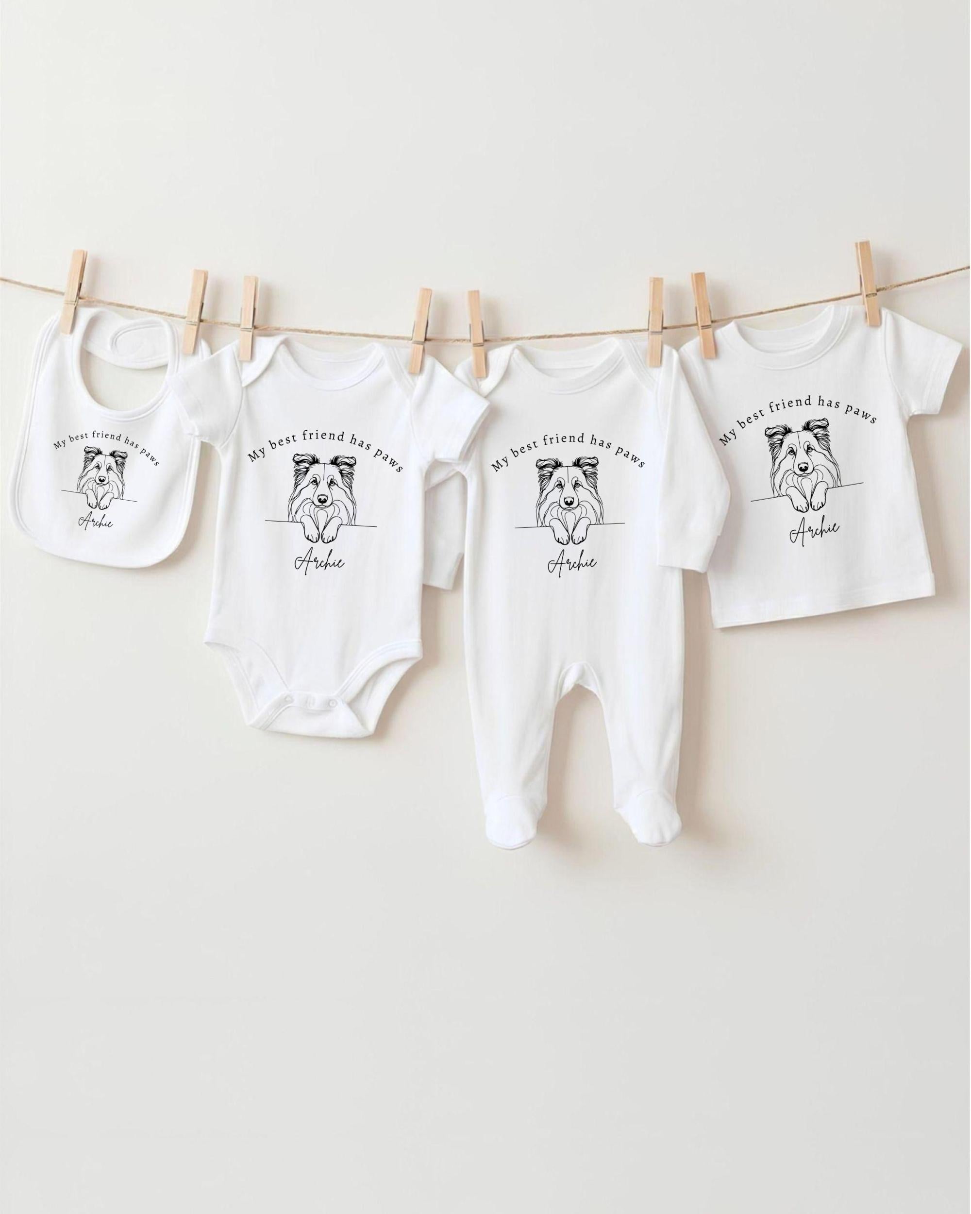 A collection of white baby clothes, including onesies and bibs, hanging on a clothesline.