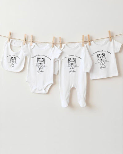 A collection of white baby clothes, including bodysuits and bibs, hanging on a clothesline.