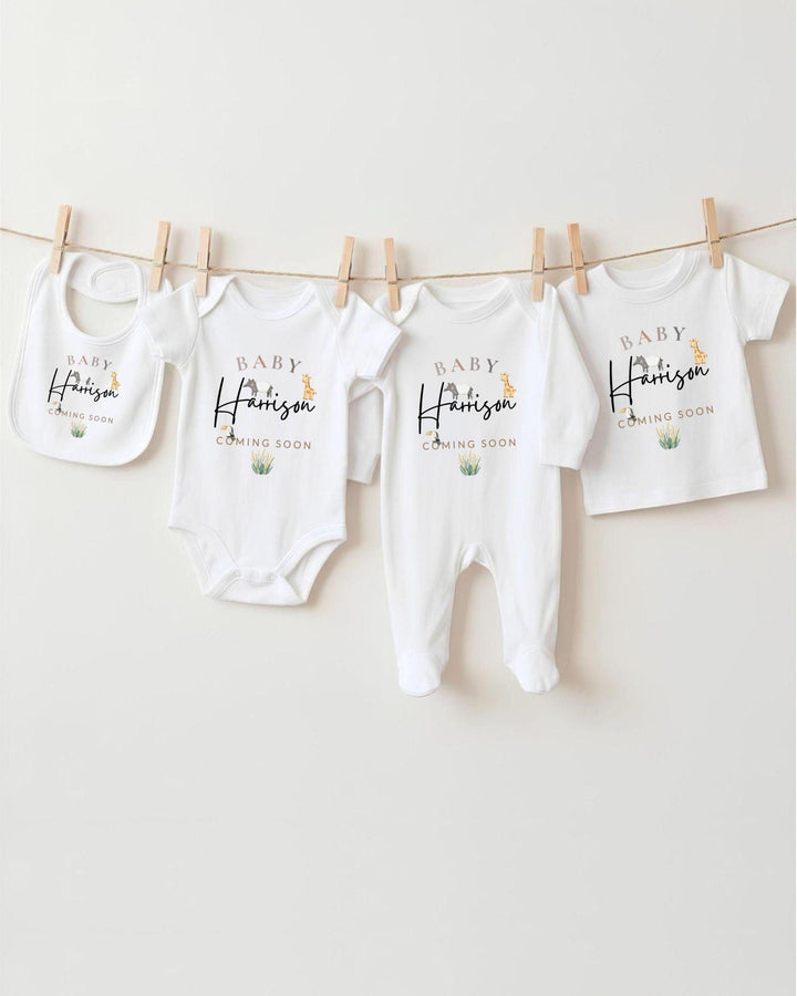 A row of white baby clothes with the name "Harison" printed on them, hanging on a clothesline.