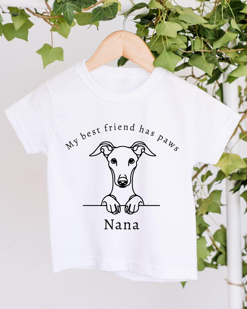 A white t-shirt with a black graphic design depicting a dog's head and paw, along with the text "My best friend has paws" and "Nana" printed on it.