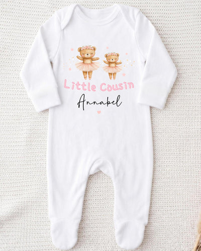 A white bodysuit with a design of two teddy bears in tutus and the text "Little Cousin Annabel" printed on it.