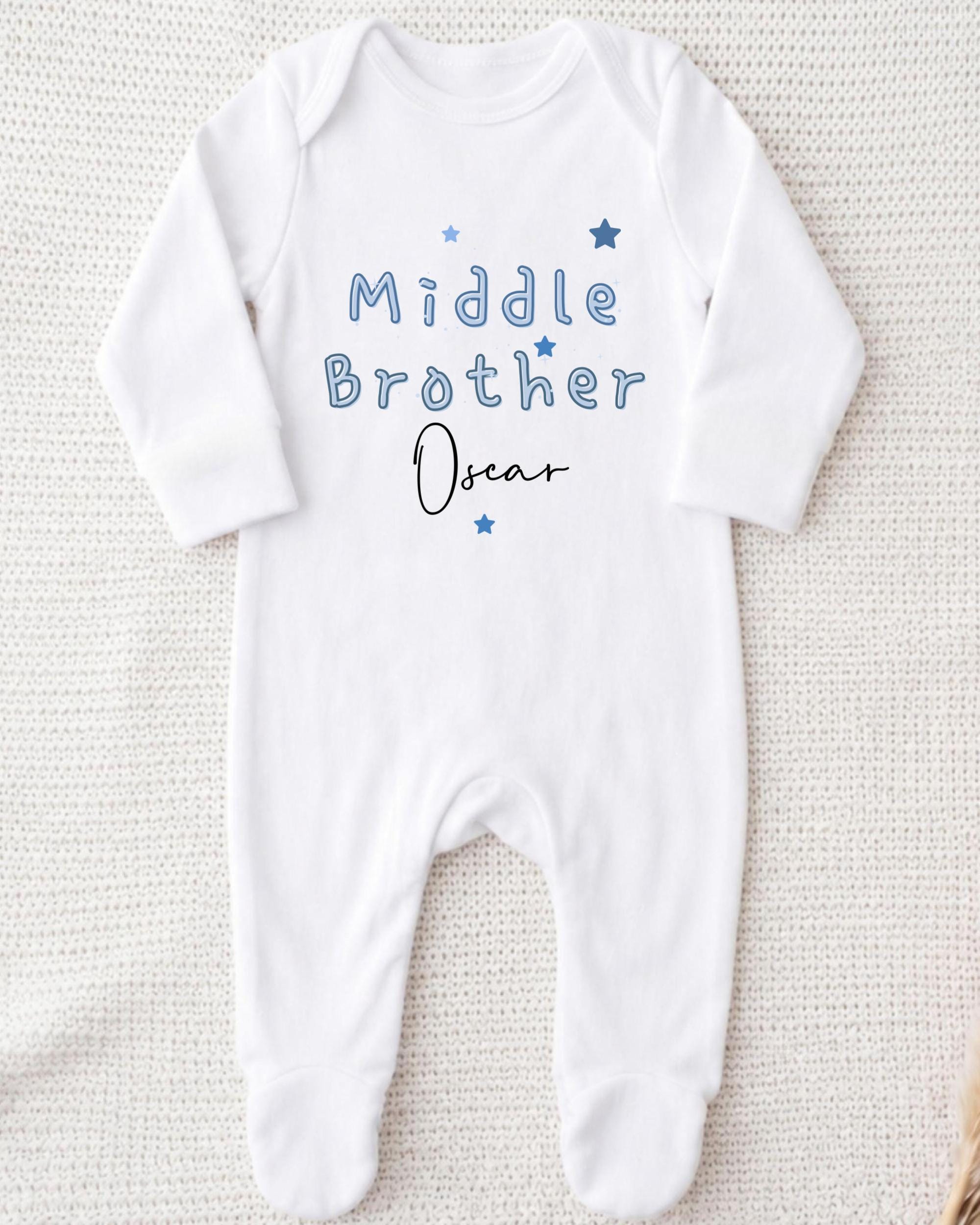A white onesie with the text "Middle Brother Oscar" printed on it.