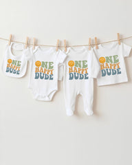 A collection of baby clothes, including onesies and bibs, hanging on a clothesline.