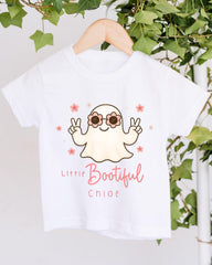 A white t-shirt with a cartoon ghost wearing sunglasses and holding a peace sign, with the text "Little Bootful Chloe" printed on it.