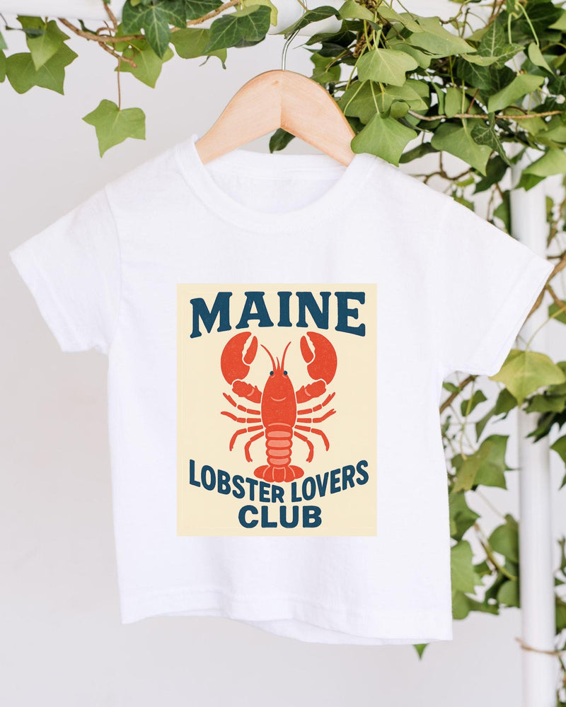 A white t-shirt with a lobster graphic and the text "MAINE LOBSTER LOYALERS CLUB" printed on it, hanging on a wooden hanger.