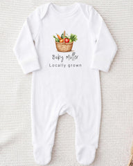A white onesie with a printed image of a basket of vegetables and the text "Baby Miller Locally grown" printed on it.