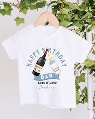 A white t-shirt with a graphic design featuring a bottle of wine and a baby bottle, along with the text "Happy Birthday Dad Lots of Love Josh".