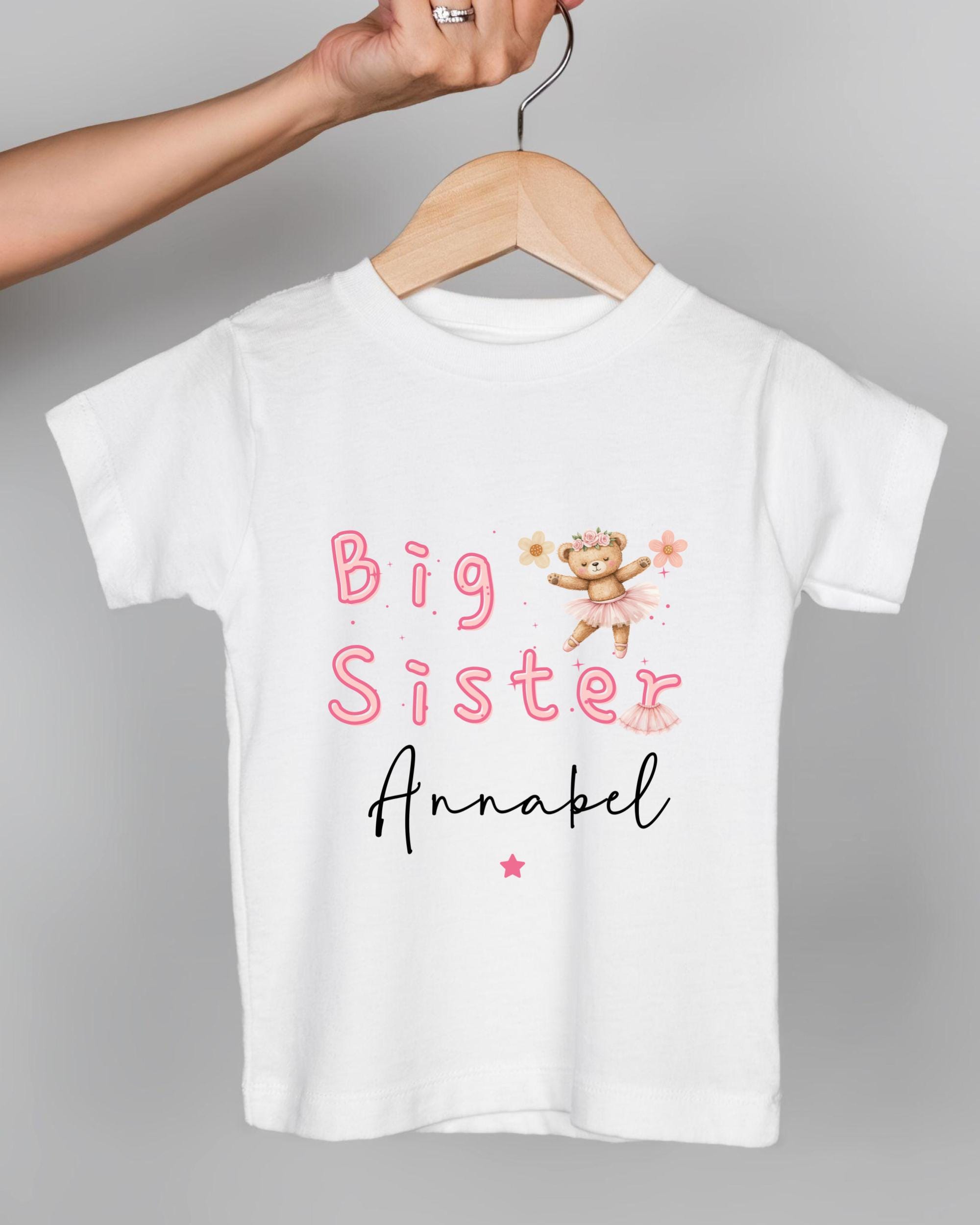 A white t-shirt with text and a teddy bear graphic.