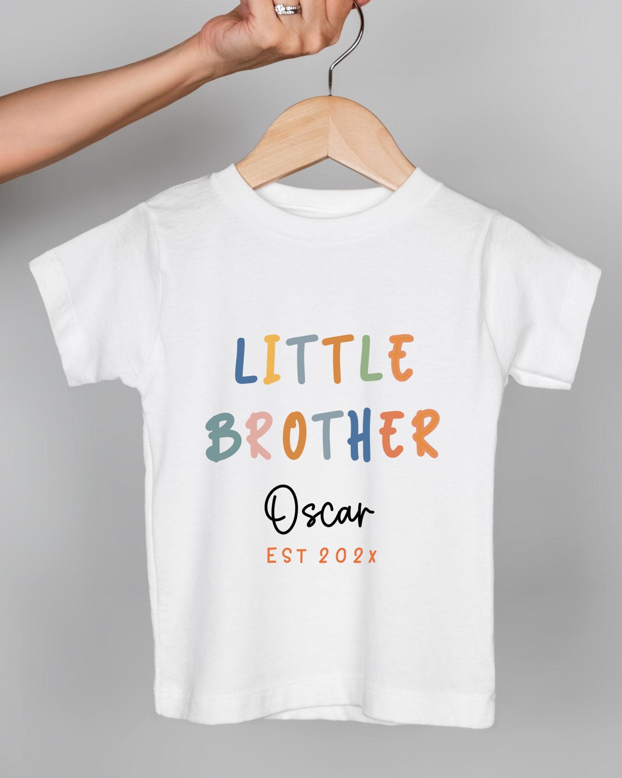A white t-shirt with the text "LITTLE BROTHER Oscar EST 202x" printed on it.