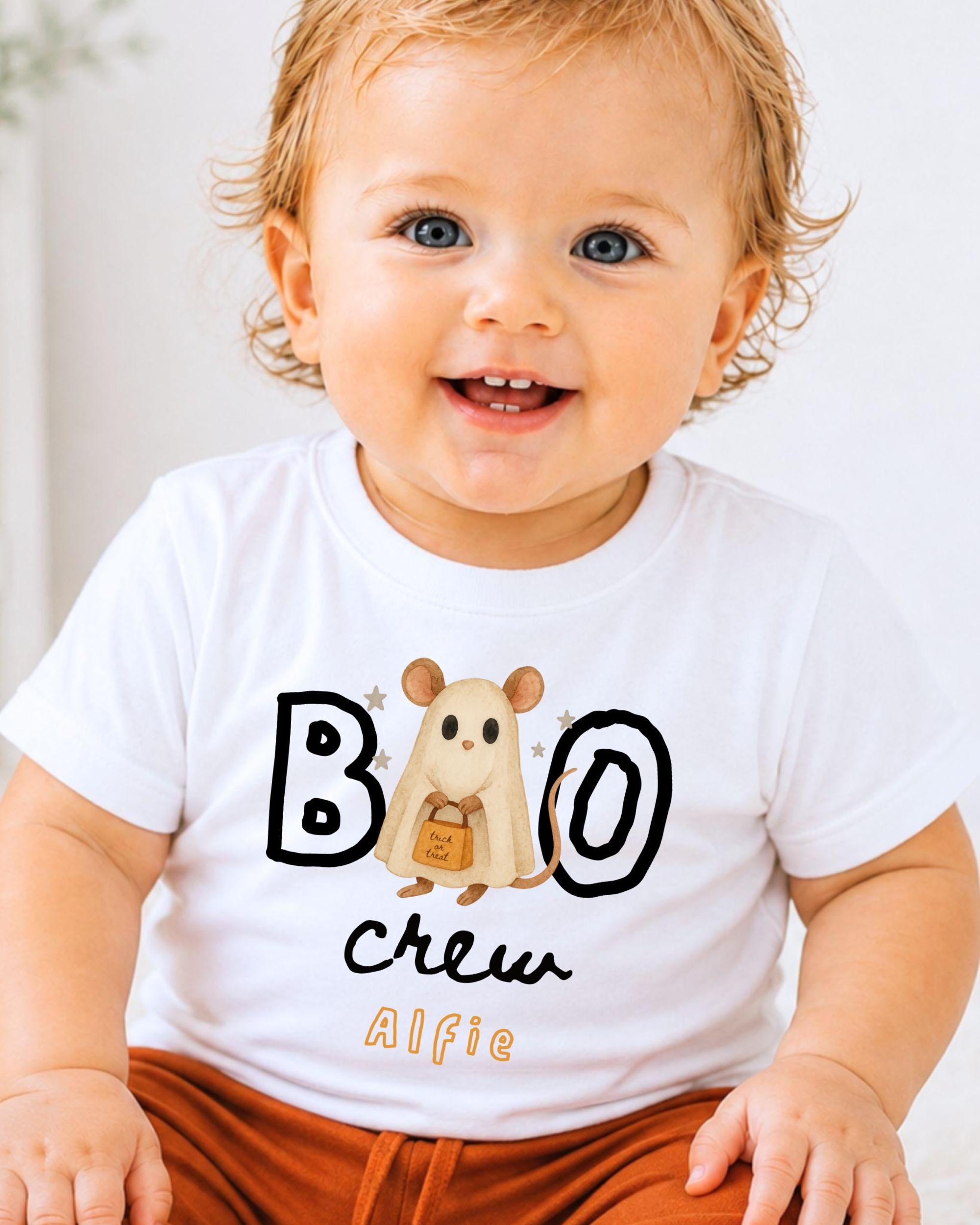 A smiling baby wearing a white t-shirt with a cartoon mouse and the text "BOO crew Alfie" printed on it.