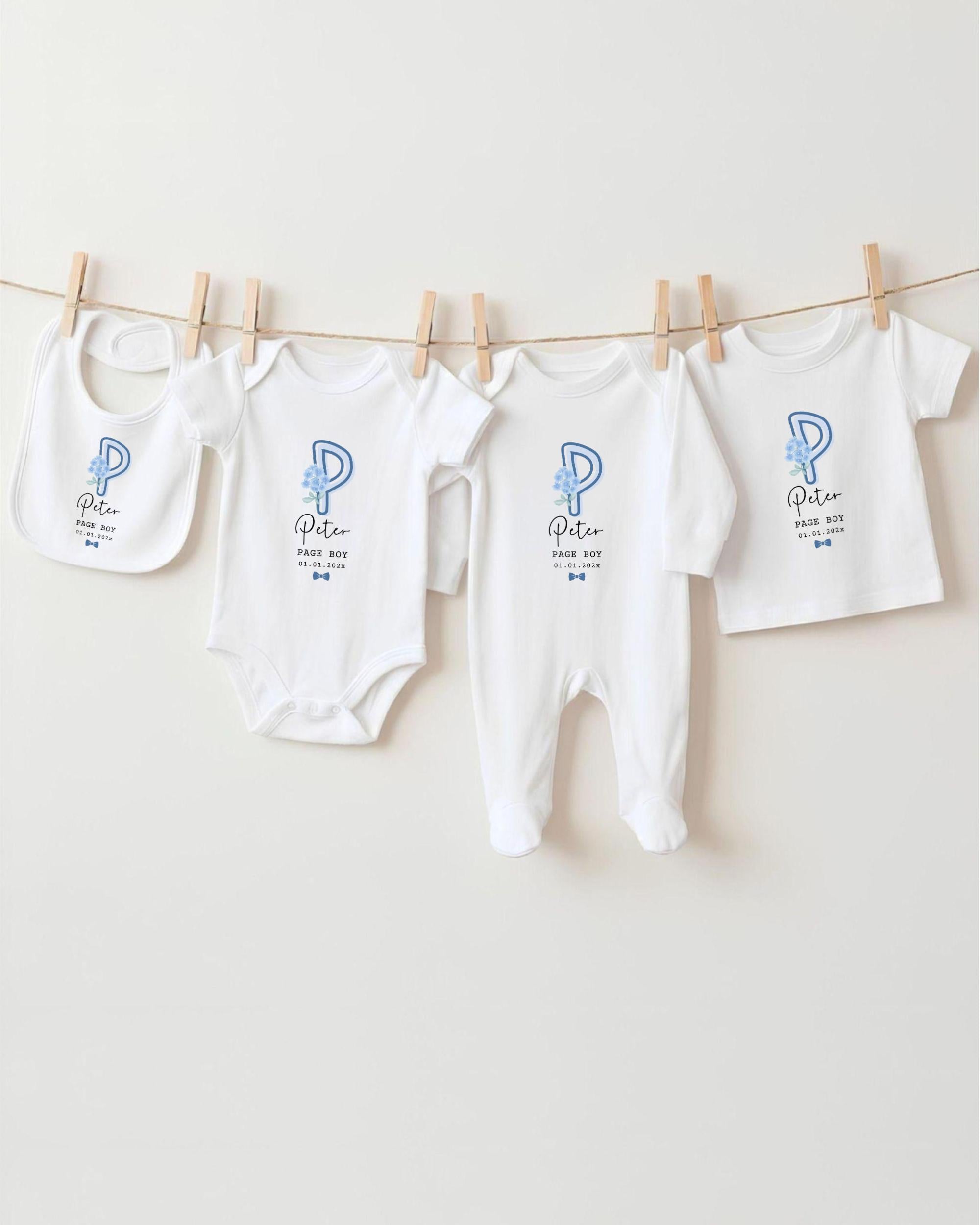 A row of white baby clothes with a blue letter "P" on them, hanging on a clothesline.
