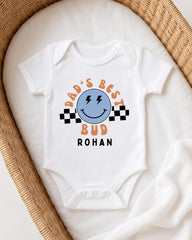 A white onesie with a graphic design on it, placed in a woven basket.