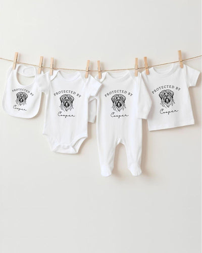 A row of four white baby clothes with the text "PROTECTED BY Cooper" printed on them, hanging on a clothesline.