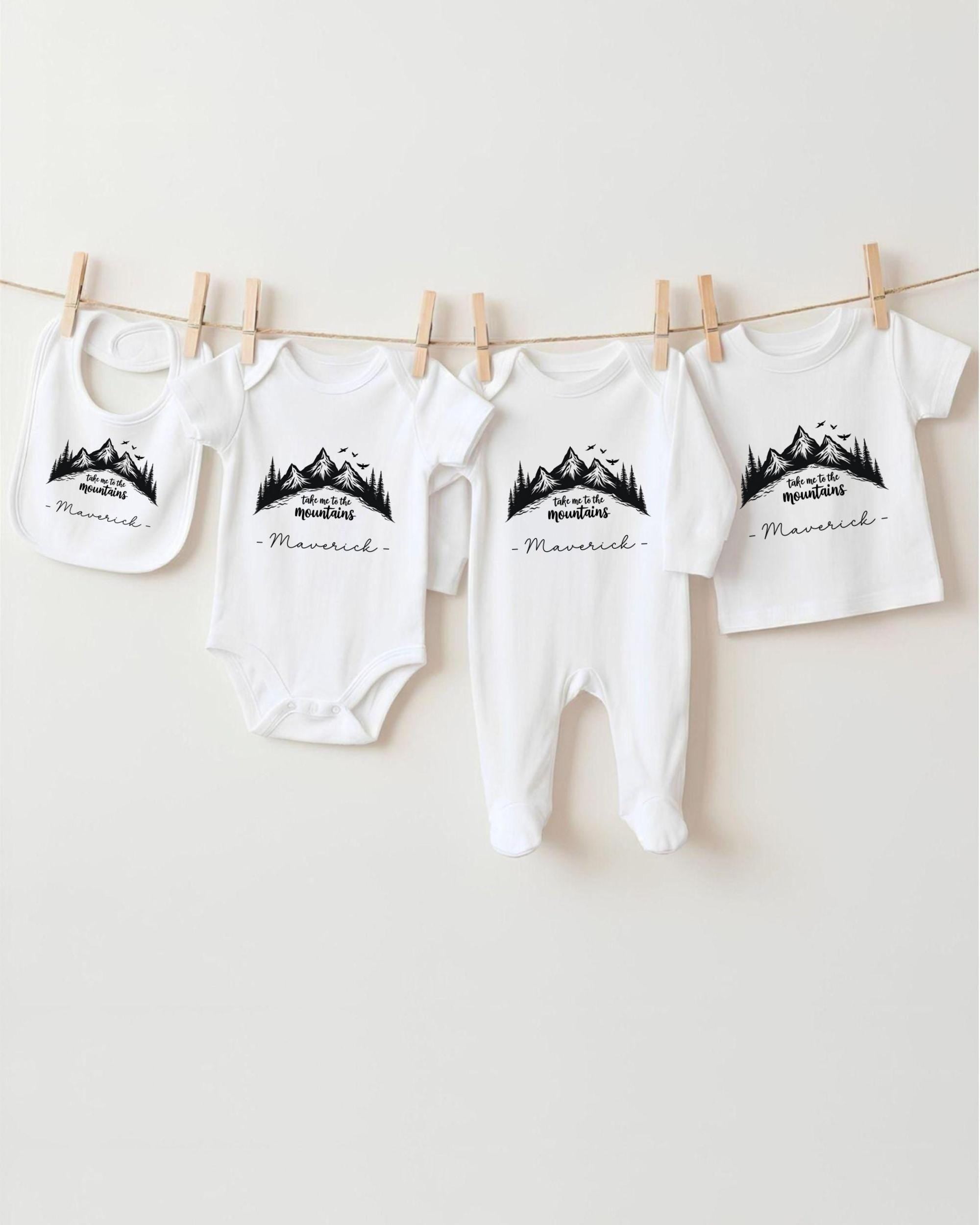 A collection of baby clothes, including onesies and pajamas, hanging on a clothesline.