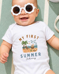 A baby wearing a white onesie with a graphic design and text, lying on a green and white striped surface.