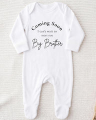 A white onesie with text that says "Coming Soon I can't wait to meet you Big Brother".