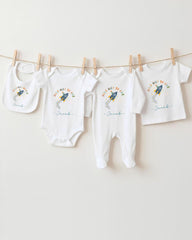 A collection of baby clothes, including onesies and bibs, hanging on a clothesline.