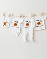 a collection of baby clothes, including bibs and onesies, hanging on a clothesline.