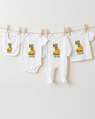 A collection of white baby clothes, including onesies and bibs, with the name " Josh" printed on them. The clothes are hanging on a clothesline, with the name " Josh" printed on each item.