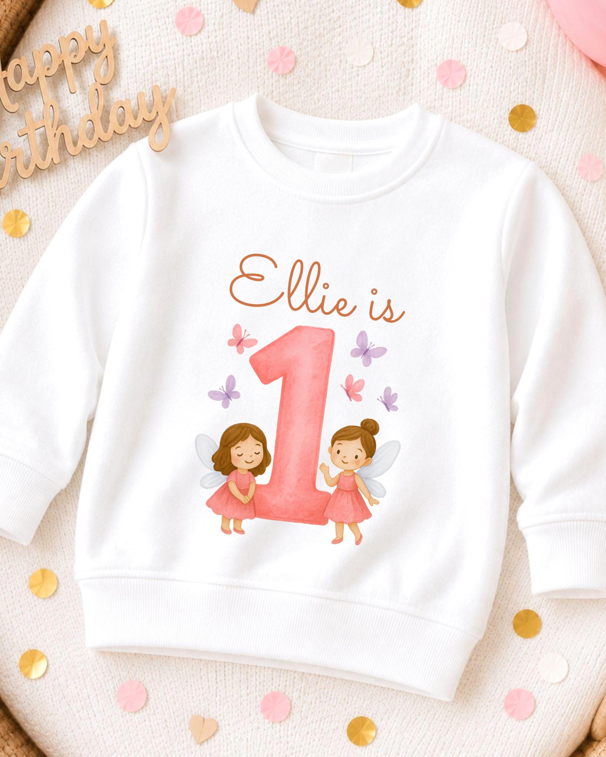 A white sweatshirt with a personalized design featuring two fairy characters and the number 1.