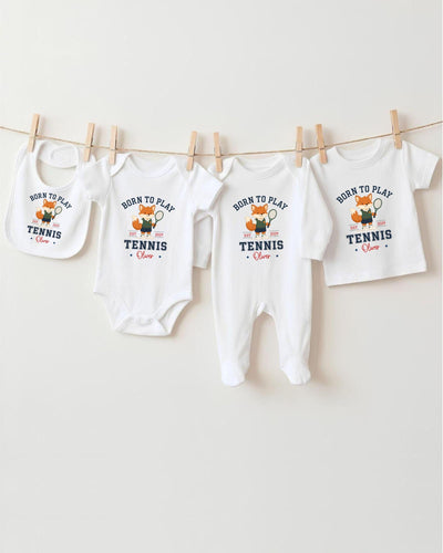 A row of four white baby clothes with the text "Born to play tennis" printed on them, along with a tennis racket and a tennis player.