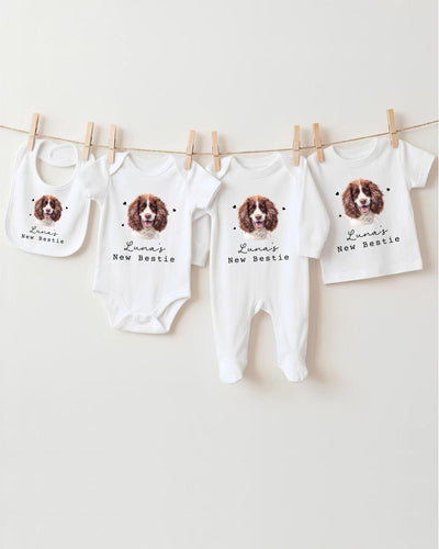 A collection of baby clothes and bibs featuring a dog image, with the text "Luna's New Bestie" printed on them.
