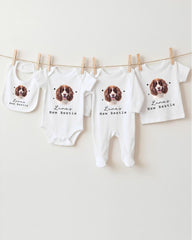 A collection of baby clothes and bibs featuring a dog image, with the text "Luna's New Bestie" printed on them.