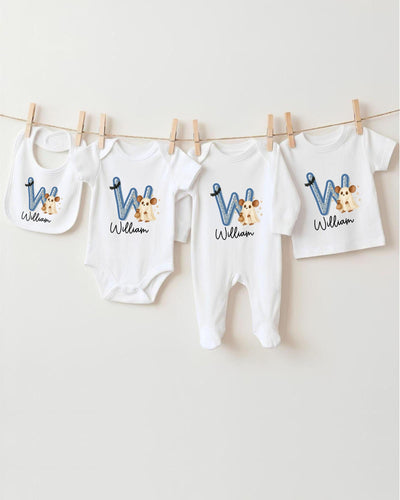 A collection of baby clothes, including bodysuits and bibs, hanging on a clothesline.