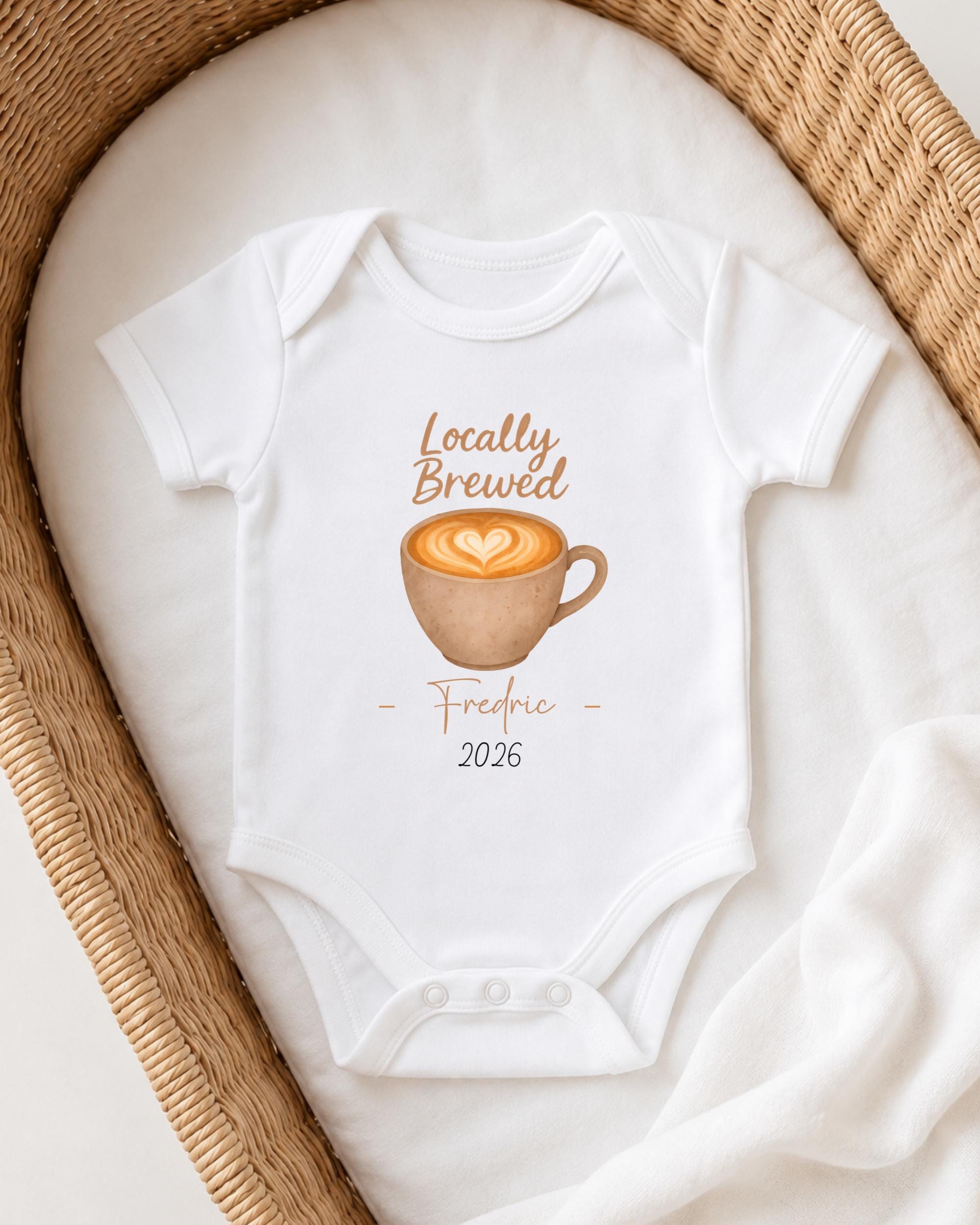 A white onesie with a coffee cup design and text printed on it, placed in a woven basket.