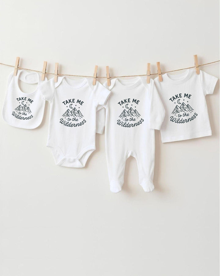 A collection of baby clothes, including onesies and bibs, hanging on a clothesline.