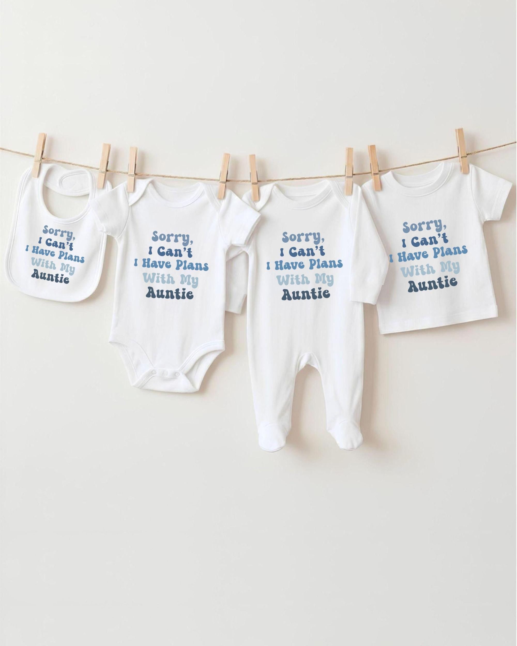 a row of baby clothes hanging on a clothesline, with each piece of clothing having a different message printed on it.