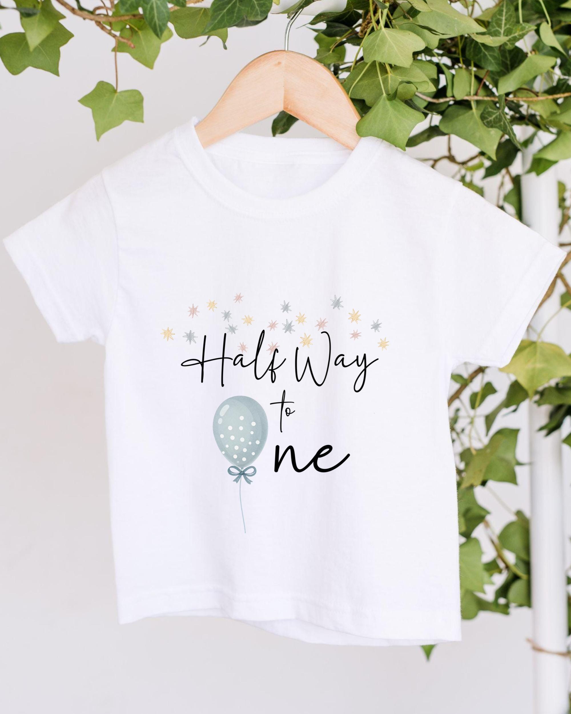 A white t-shirt with a graphic design and text printed on it, hanging on a wooden hanger.