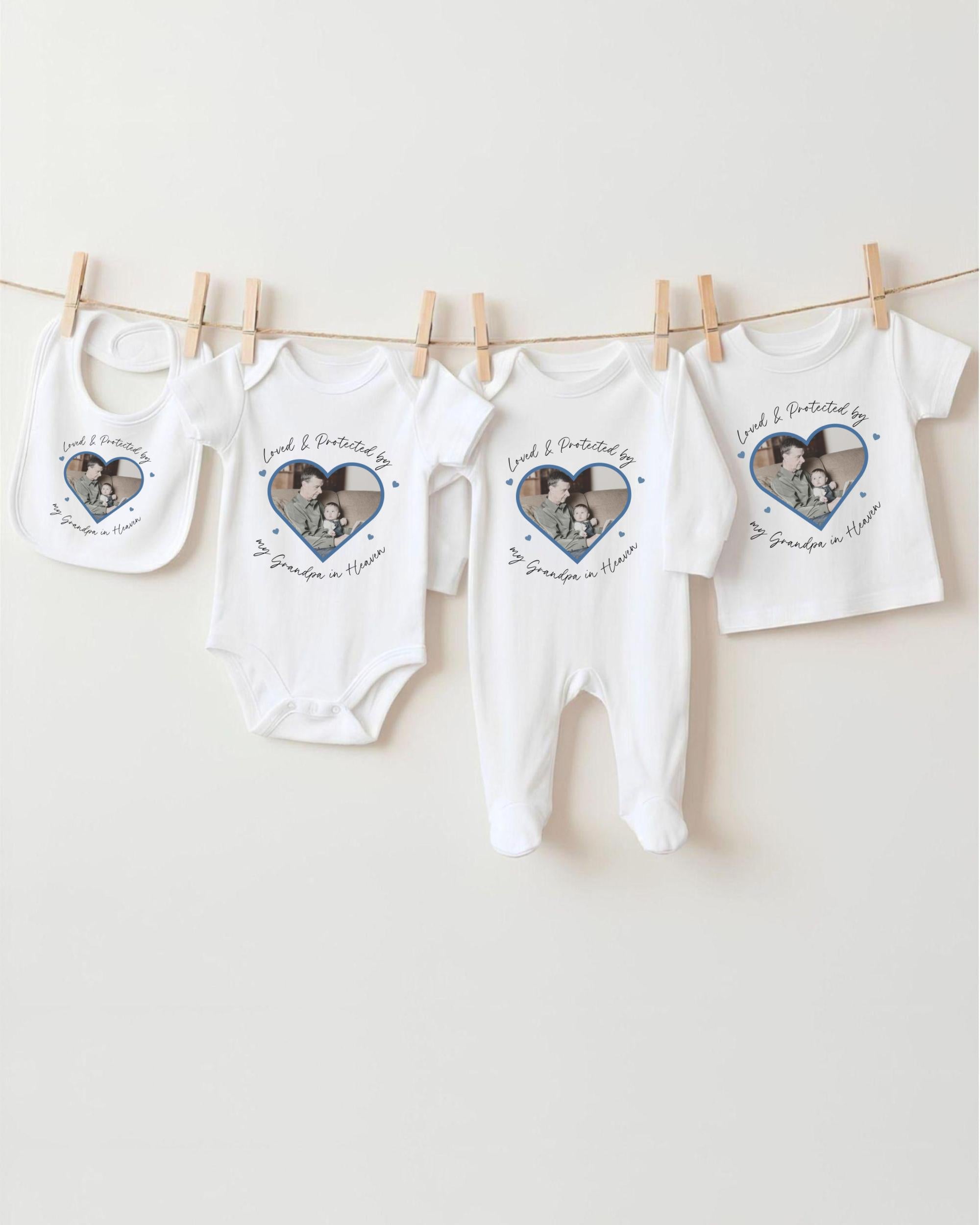 A collection of white baby clothes, including onesies and pajamas, hanging on a clothesline.