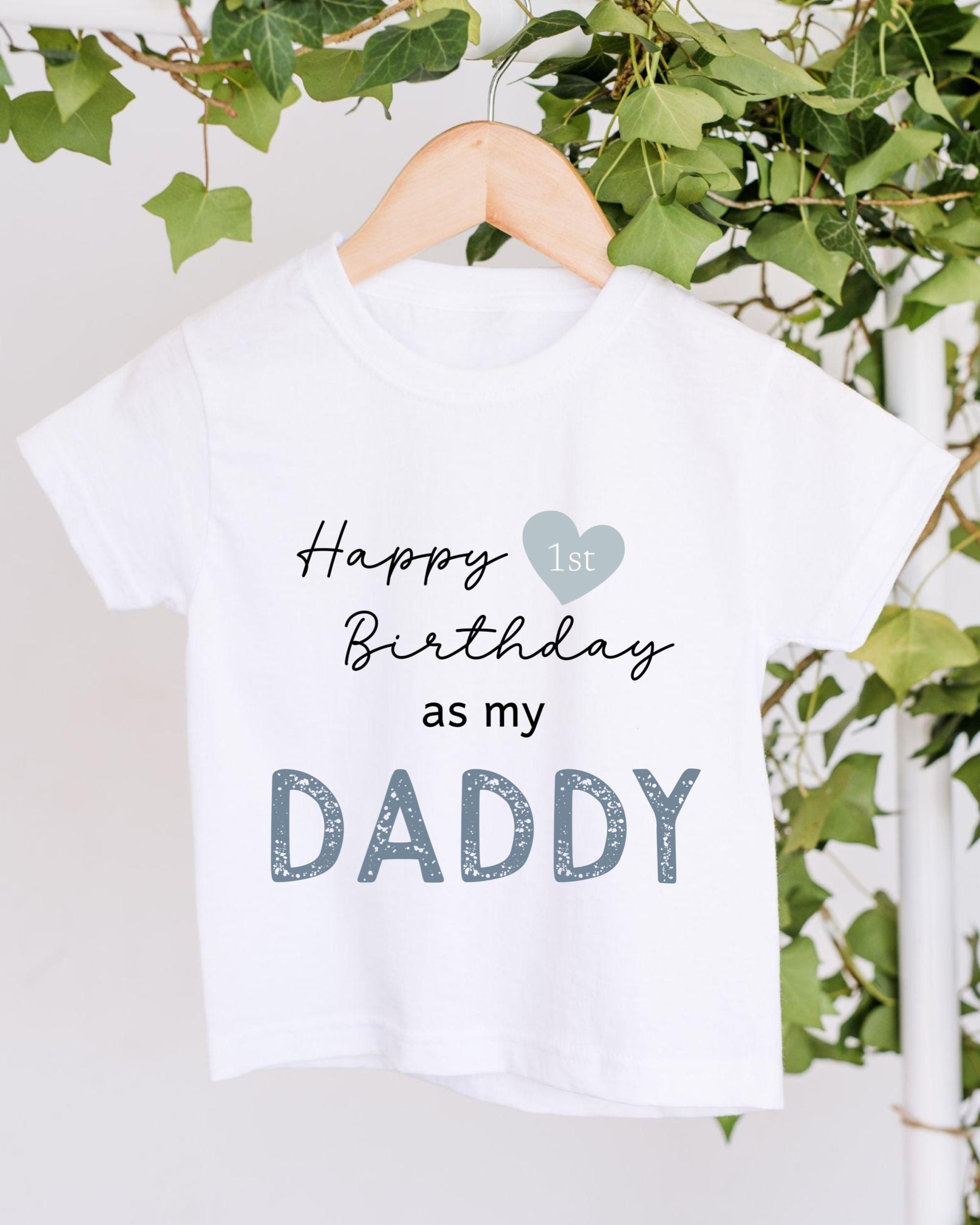 A white t-shirt with text that reads "Happy 1st Birthday as my DADDY" printed on it.