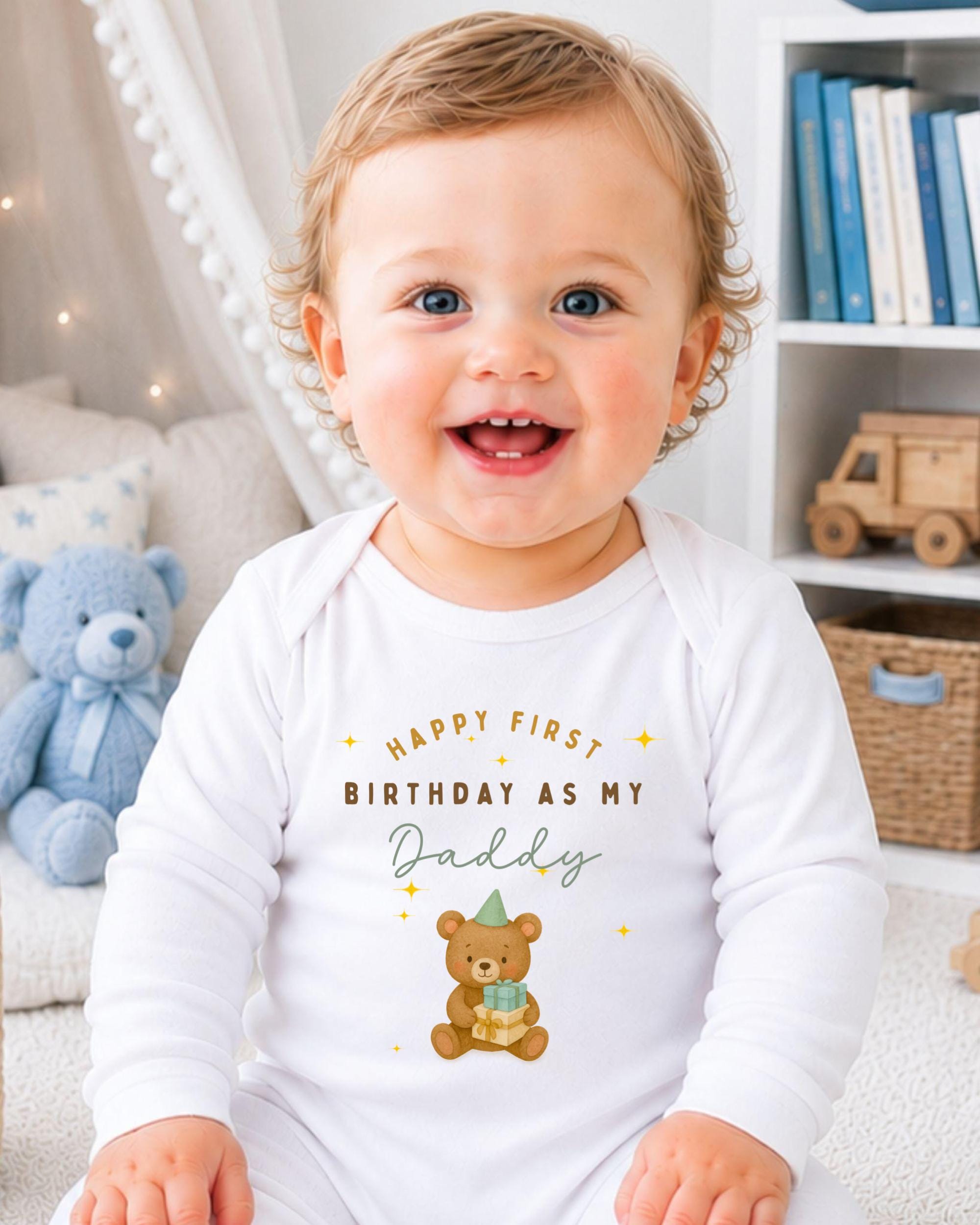 A smiling baby wearing a white onesie with a teddy bear and text that says "Happy first birthday as my Daddy".