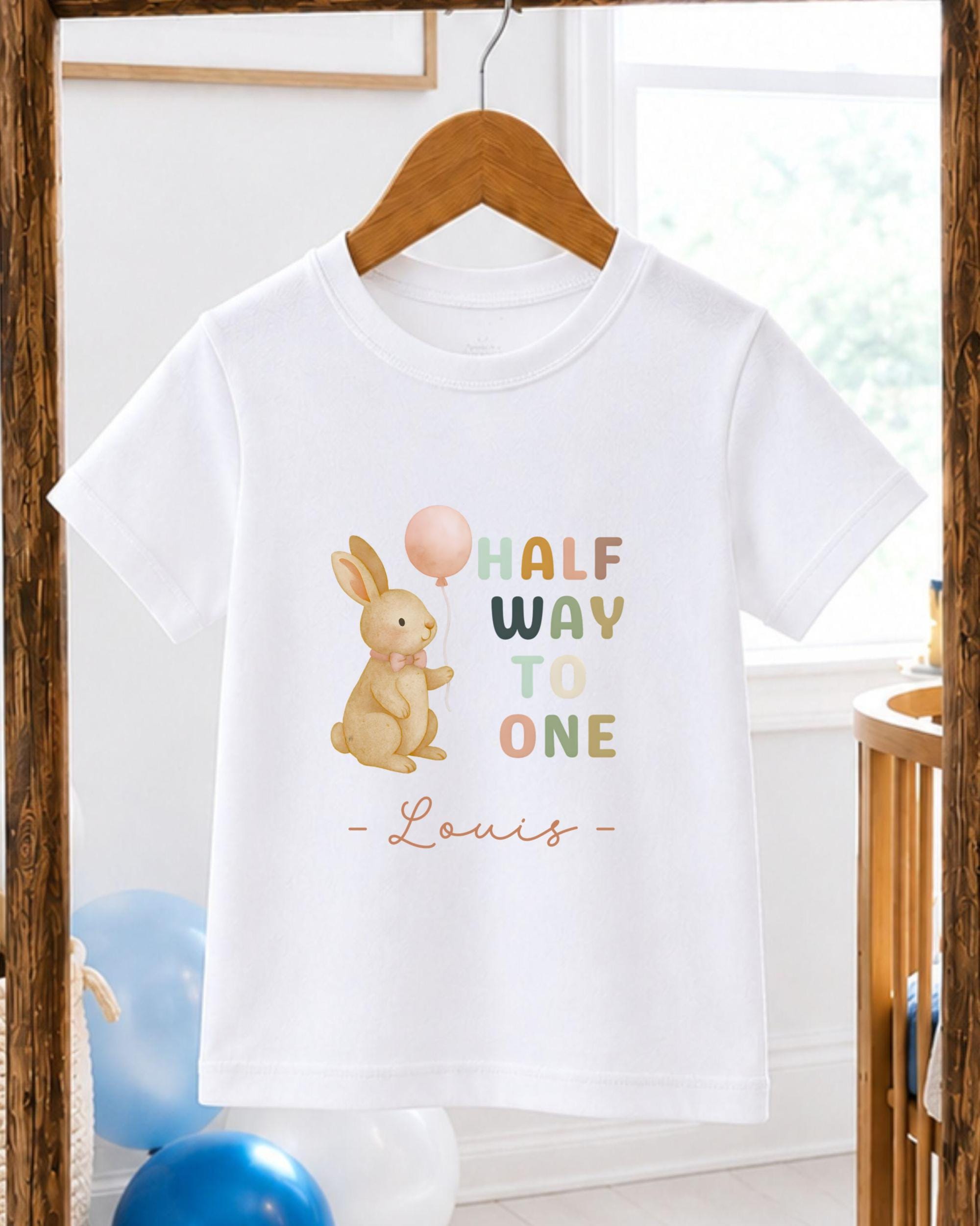 A white t-shirt with a cartoon rabbit holding a balloon and the text "Half Way to One" printed on it.