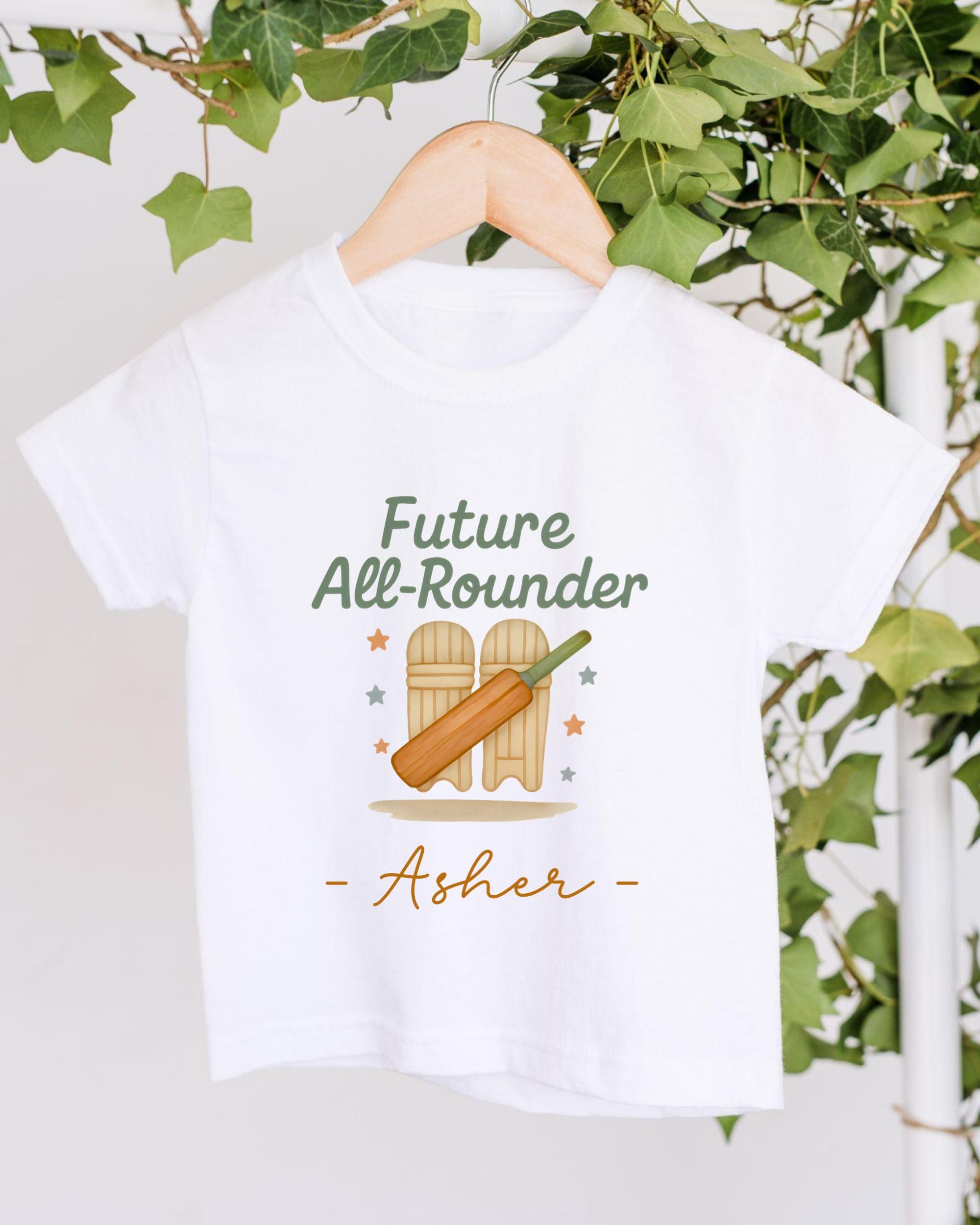 A white t-shirt with a graphic design featuring a cricket bat and the text "Future All-Rouner" and "Asher" printed on it.